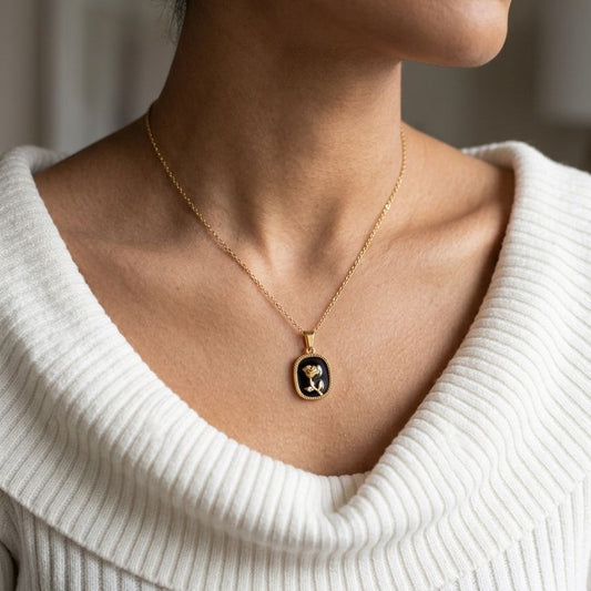 Necklace with a pendant worn by a person in a white sweater