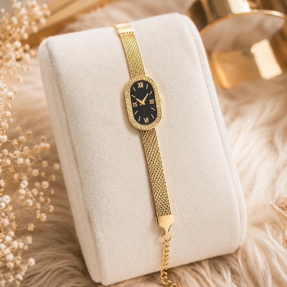 Gold watch on a white cushion with decorative elements